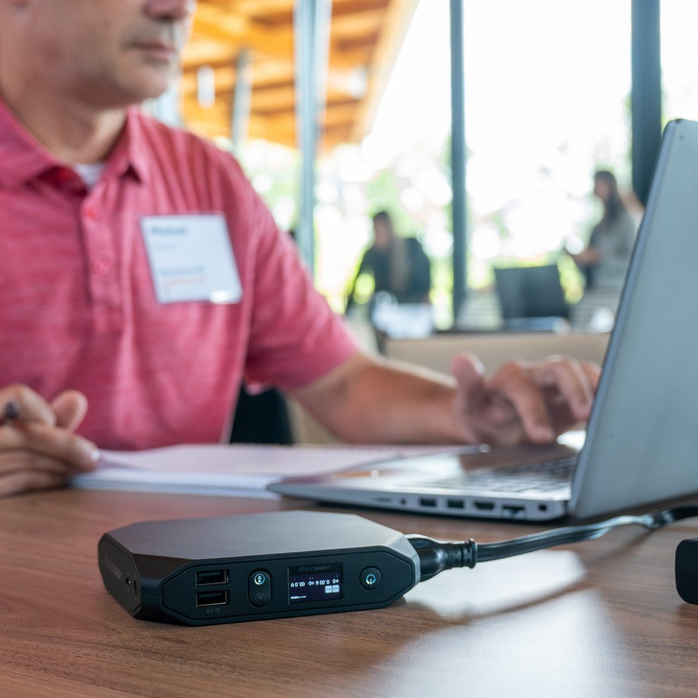 Participant working on a laptop with an Omnicharge power bank