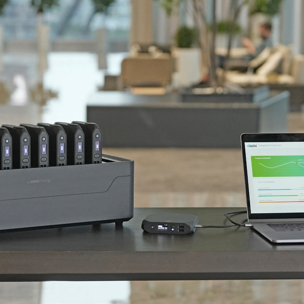 Omni Power Station next to a laptop in an open-plan office